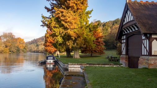 Autumn view of the river with the boat house on the left, taken at Cliveden, Buckinghamshire.